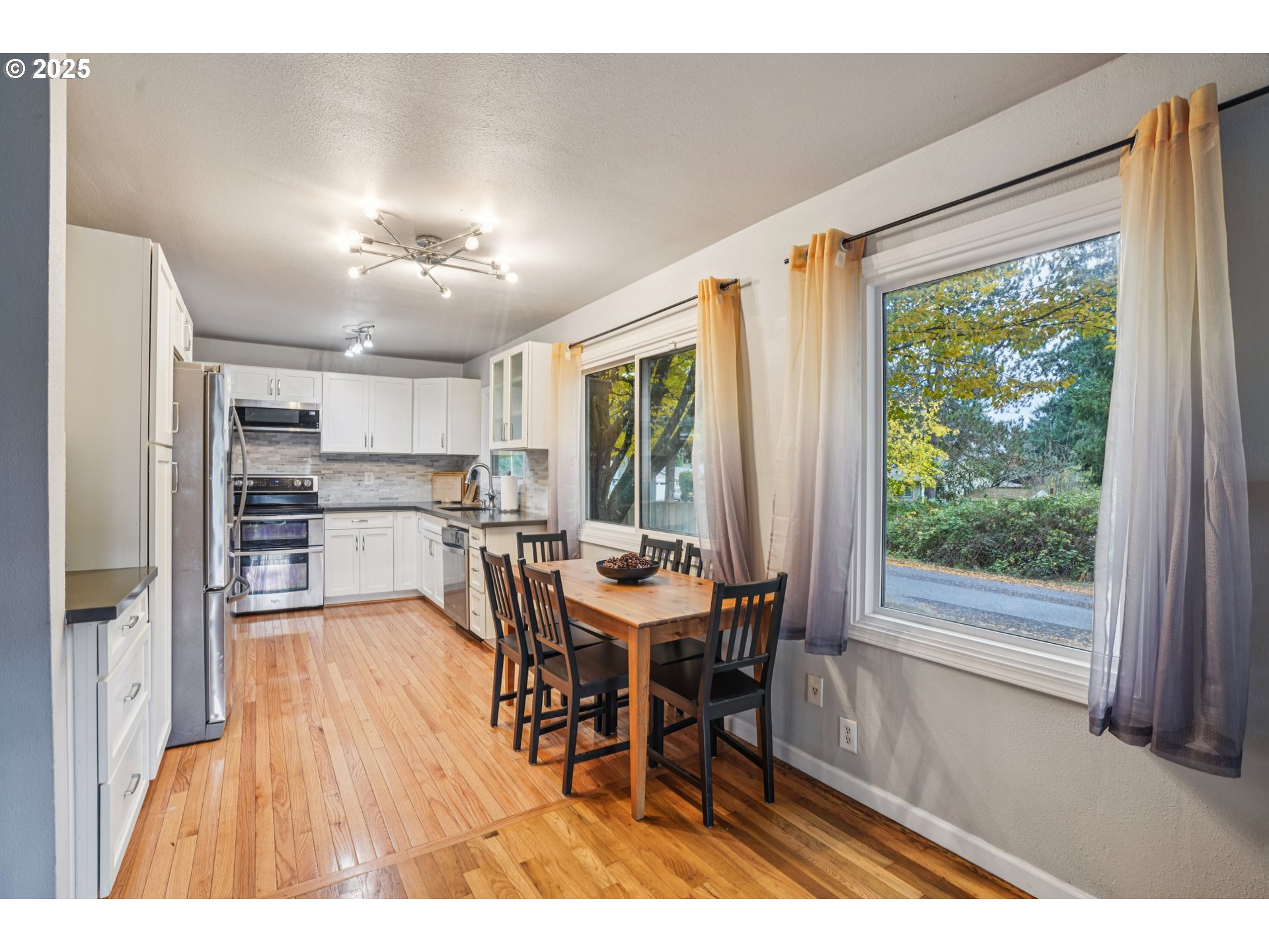 14806 Southeast Bush Street Portland, OR 97236 - Photo 7 of 33 a view of a dining room with furniture window and wooden floor