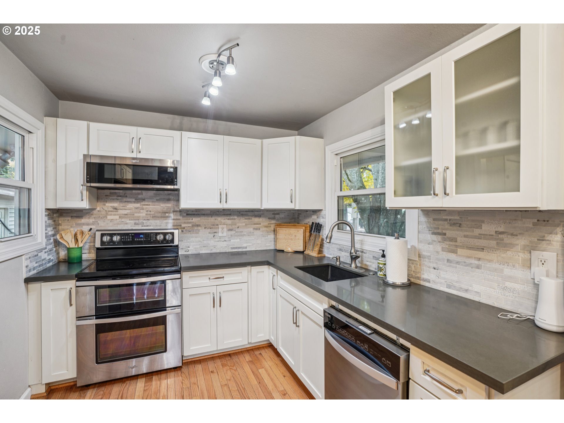 14806 Southeast Bush Street Portland, OR 97236 - Photo 9 of 33 a kitchen with stainless steel appliances a stove sink microwave and cabinets