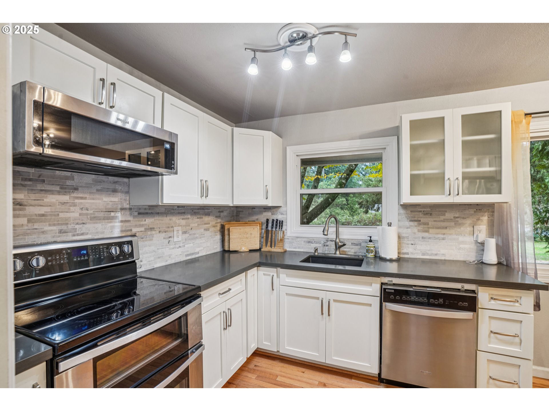 14806 Southeast Bush Street Portland, OR 97236 - Photo 10 of 33 a kitchen with stainless steel appliances a sink cabinets and a window