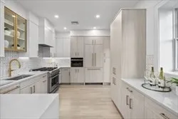 a large white kitchen with a stove and a sink