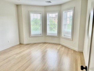 1574 Beacon Street, Unit U: PH2 Brookline, MA 02446 - Photo 11 of 11 an empty room with wooden floor and windows