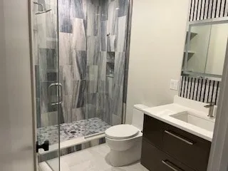a bathroom with a sink a toilet and shower