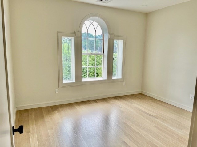 1574 Beacon Street, Unit U: PH2 Brookline, MA 02446 - Photo 9 of 11 an empty room with wooden floor and windows