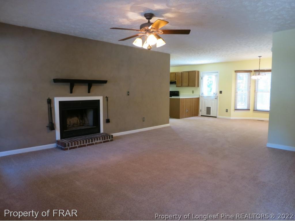 6875 Green Creek Road Fayetteville, NC 28314 - Photo 3 of 26 a view of a livingroom with a fireplace and a chandelier fan
