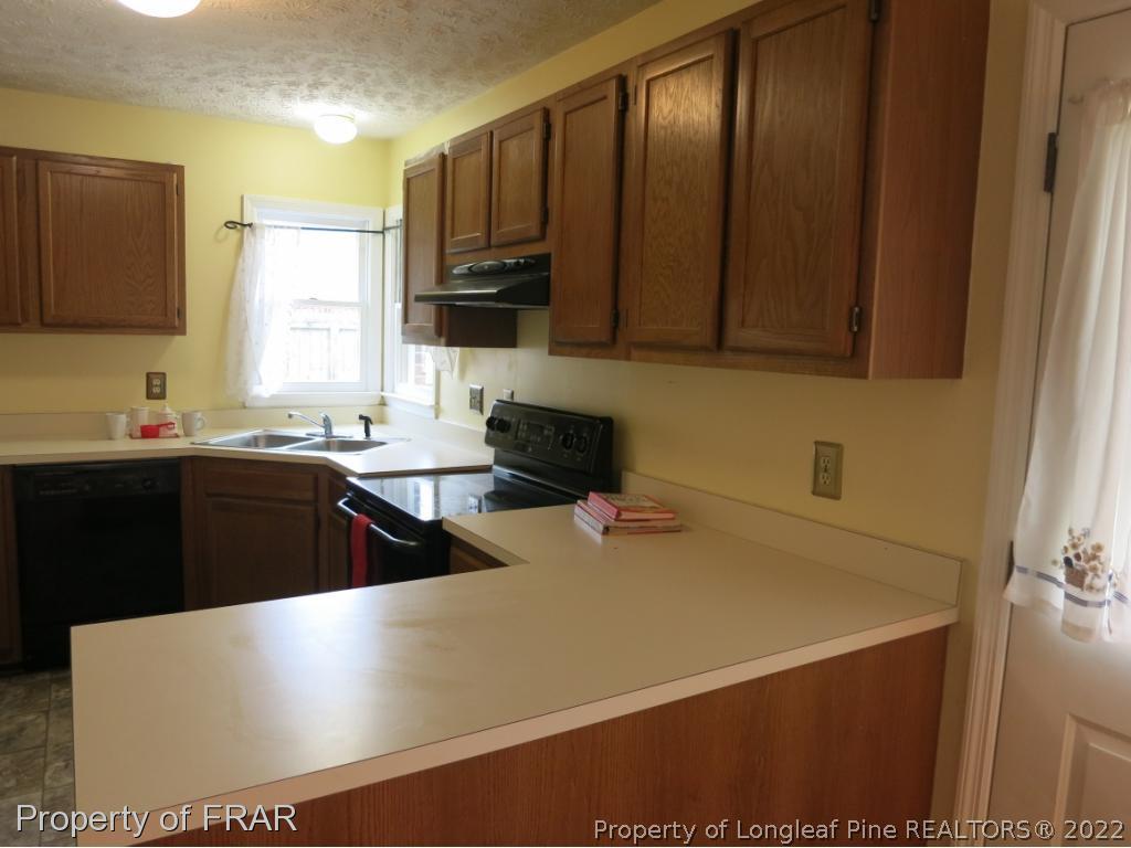 6875 Green Creek Road Fayetteville, NC 28314 - Photo 7 of 26 a kitchen with a sink a stove and cabinets