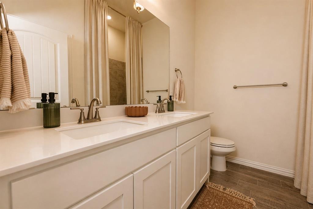 1530 County Road 200 Valley View, TX 76272 - Photo 30 of 34 Bathroom featuring a double vanity with white cabinetry, integrated sinks, and brushed nickel faucets