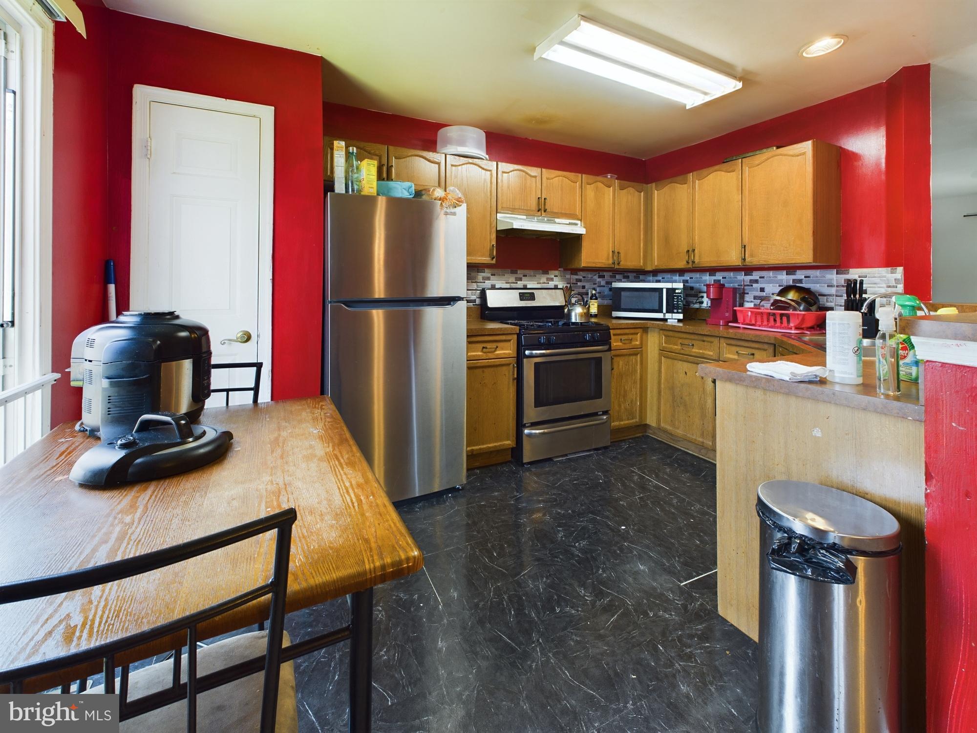 9620 Button Buck Circle Randallstown, MD 21133 - Photo 8 of 32 a kitchen with refrigerator a stove a sink a dining table and chairs