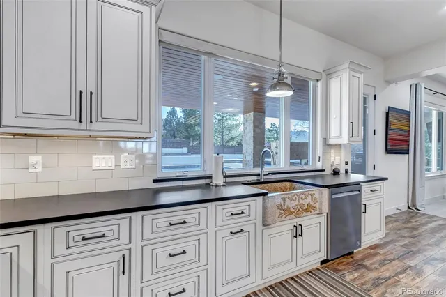 a kitchen with granite countertop a sink stainless steel appliances and cabinets