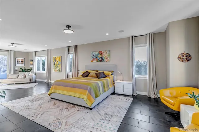 a spacious bedroom with a bed and glass windows