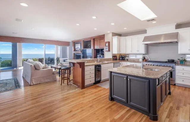 a kitchen with stainless steel appliances granite countertop a table chairs stove a sink dishwasher and cabinets