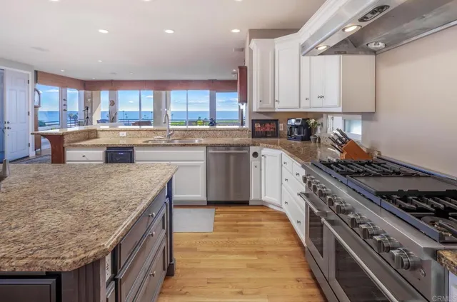 a kitchen with stainless steel appliances granite countertop a stove a sink and a refrigerator