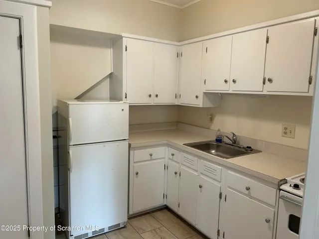a kitchen with white cabinets and white appliances