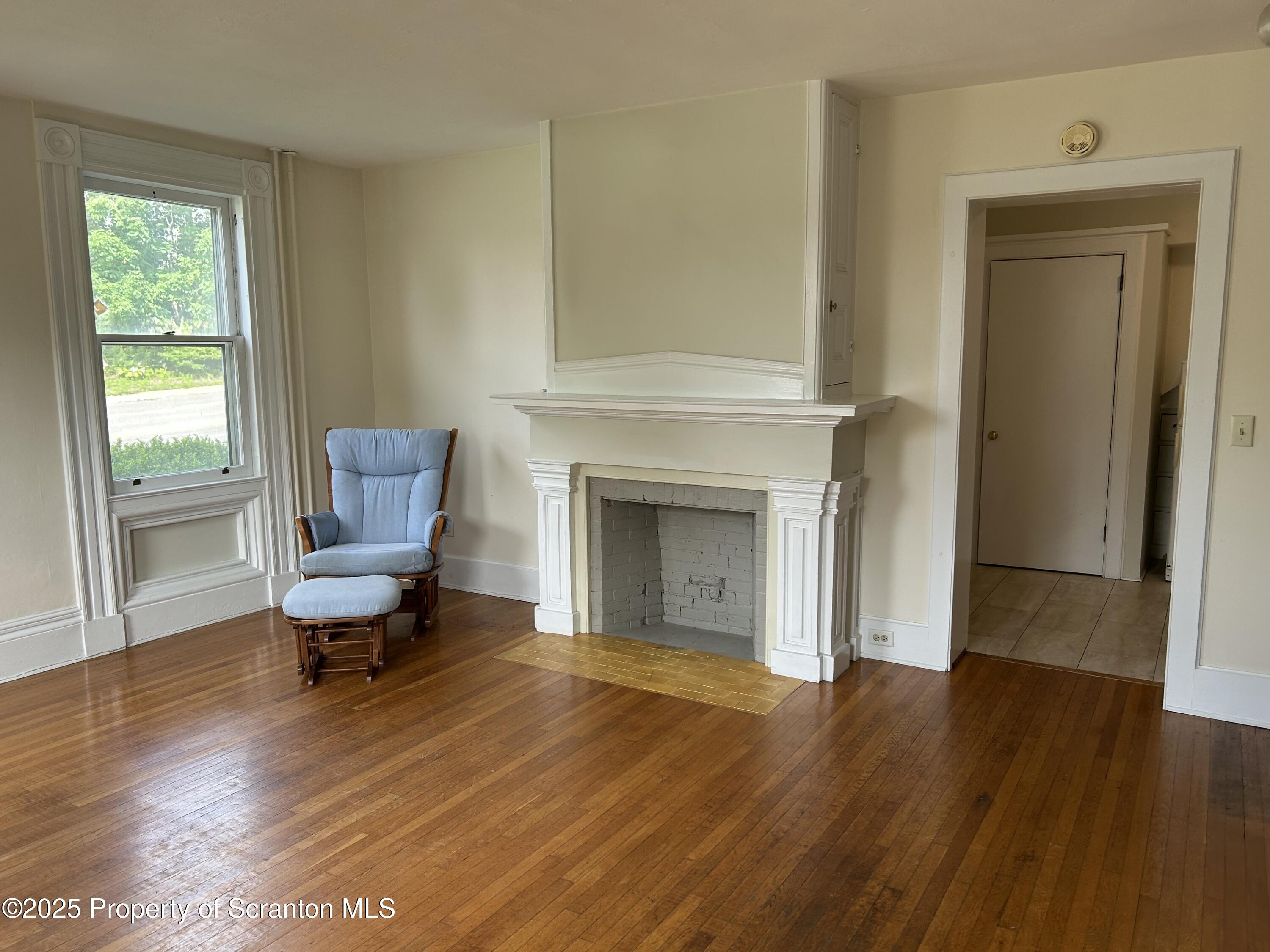 344 Church Street, Unit 1 Montrose, PA 18801 - Photo 5 of 10 a living room with a fireplace and wooden floor