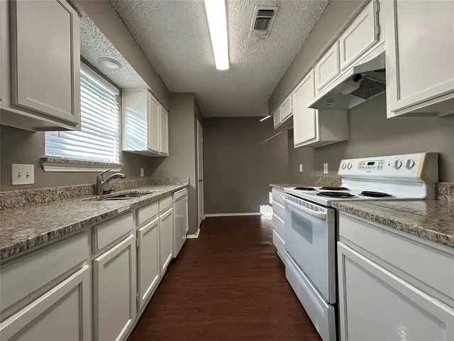 a kitchen with stainless steel appliances granite countertop a sink and a stove