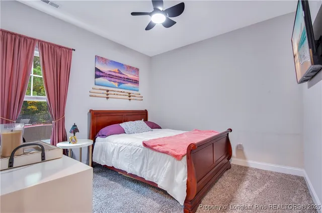 a bathroom with a granite countertop sink toilet and painting on the wall