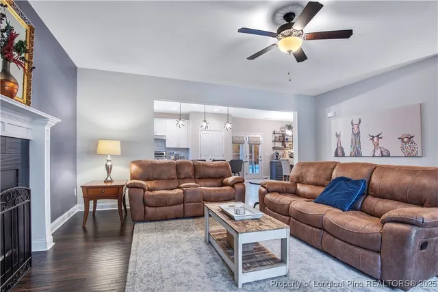 a living room with furniture a ceiling fan and a window