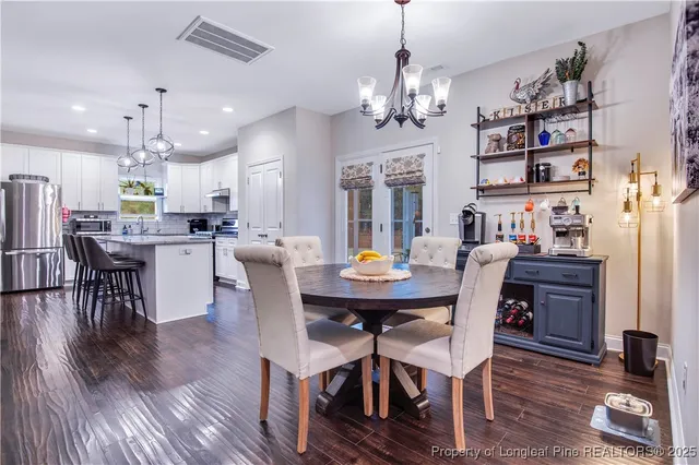 a kitchen with stainless steel appliances a refrigerator a sink dishwasher a stove and white countertops with wooden floor