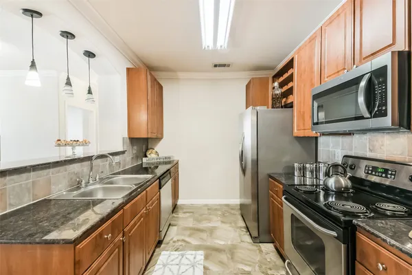 a kitchen with stainless steel appliances granite countertop a sink stove and microwave