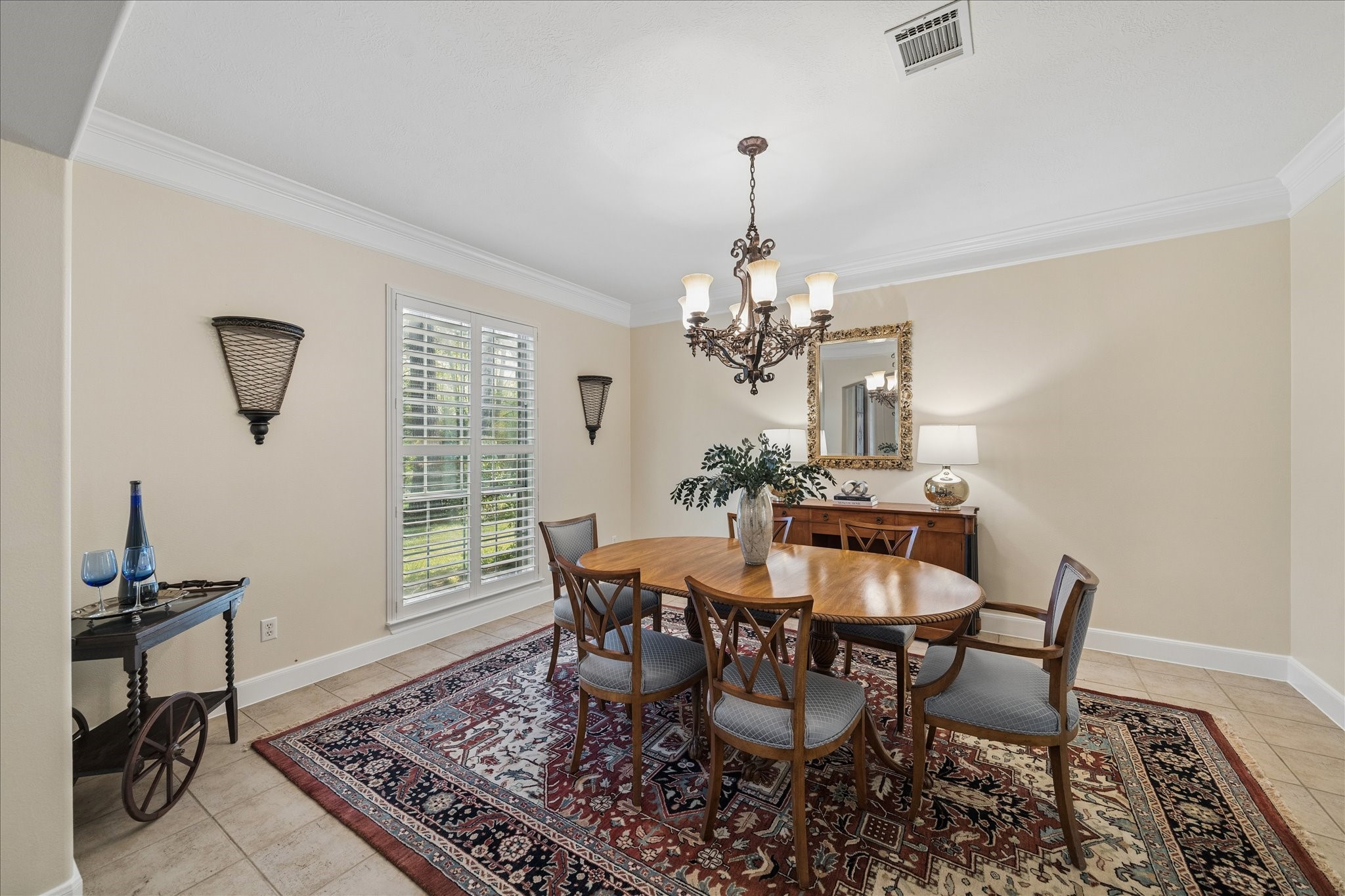 14530 Millhouse Road Pinehurst, TX 77362 - Photo 7 of 46 Formal dining room with chandelier, crown molding, and window with plantation shutters, providing natural light and space for hosting gatherings and special occasions.