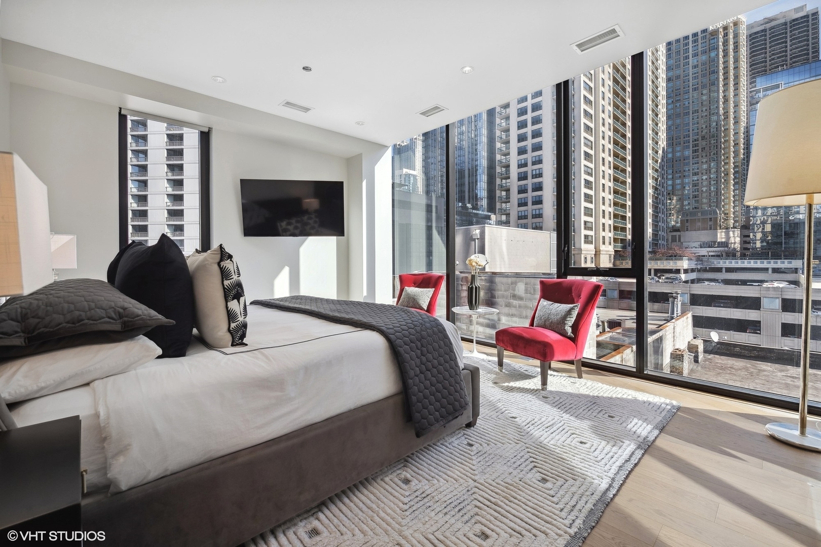 56 West Huron Street, Unit 6 Chicago, IL 60654 - Photo 27 of 32 a bedroom with a bed a flat screen tv and a large window