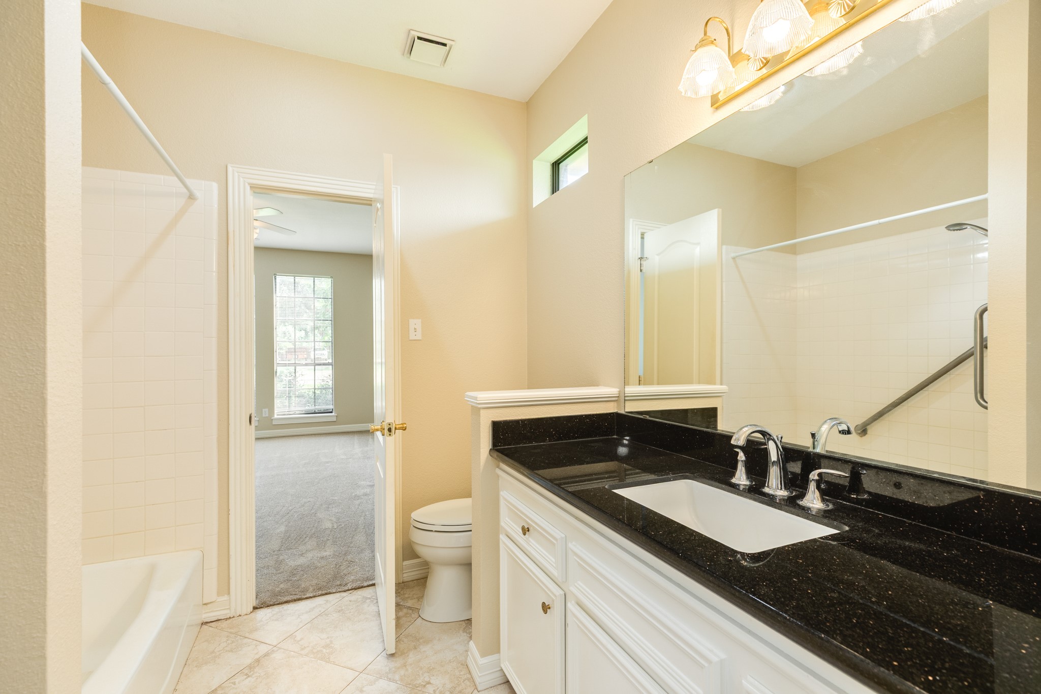 704 Walnut Street Lake Jackson, TX 77566 - Photo 20 of 27 a spacious bathroom with a granite countertop sink and a mirror