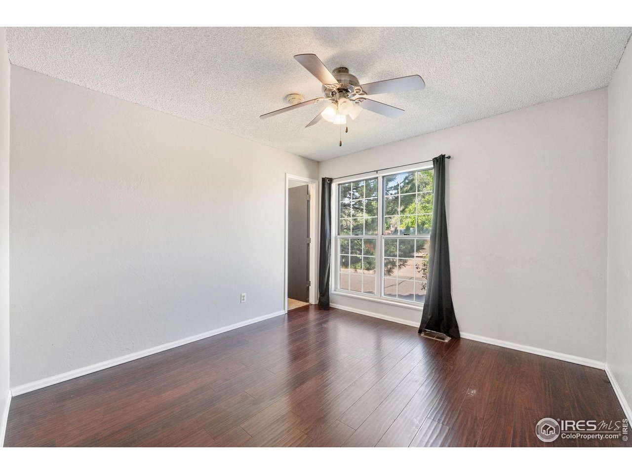 1305 Inverness Drive Lafayette, CO 80026 - Photo 12 of 41 a view of an empty room with wooden floor and a window