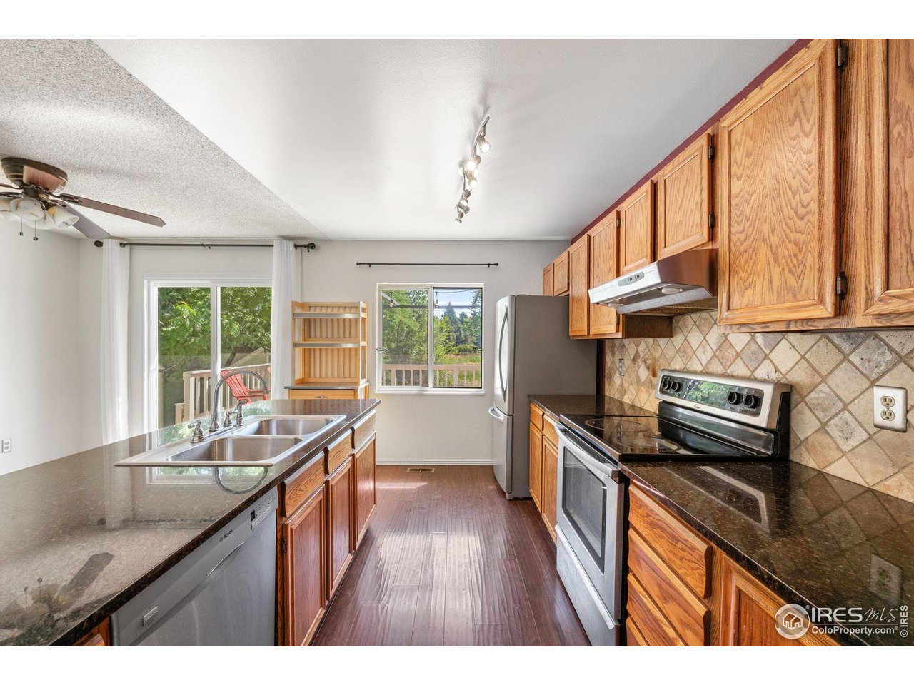 1305 Inverness Drive Lafayette, CO 80026 - Photo 18 of 41 a kitchen with stainless steel appliances granite countertop a sink a stove and a wooden floors