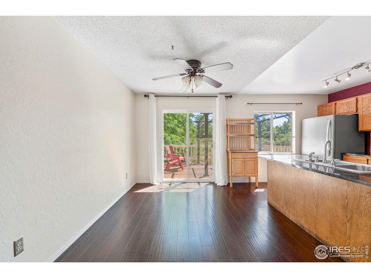 1305 Inverness Drive Lafayette, CO 80026 - Photo 19 of 41 a view of a livingroom with furniture a ceiling fan and wooden floor