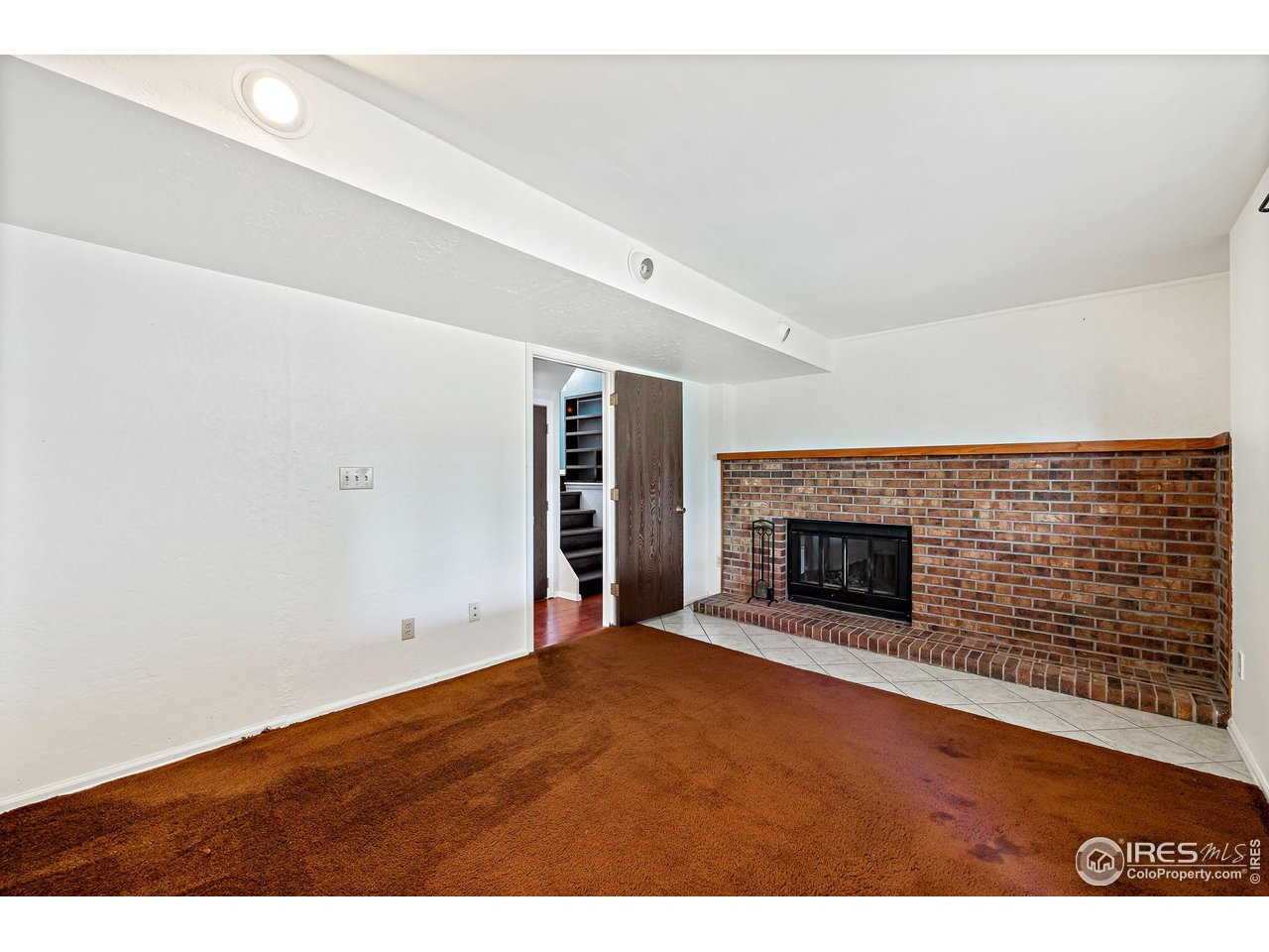 1305 Inverness Drive Lafayette, CO 80026 - Photo 25 of 41 a view of an empty room with wooden floor fireplace and a window