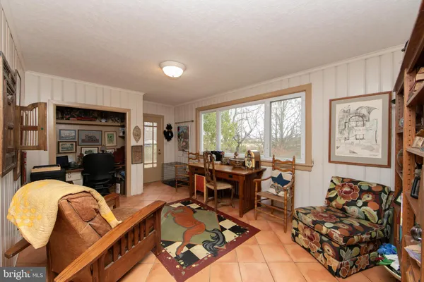 a living room with stainless steel appliances granite countertop furniture a rug kitchen view and a chandelier
