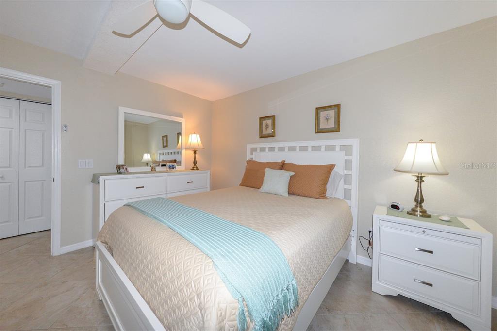 175 Kings Highway, Unit A7 Punta Gorda, FL 33983 - Photo 20 of 36 a spacious bedroom with a bed and a lamp