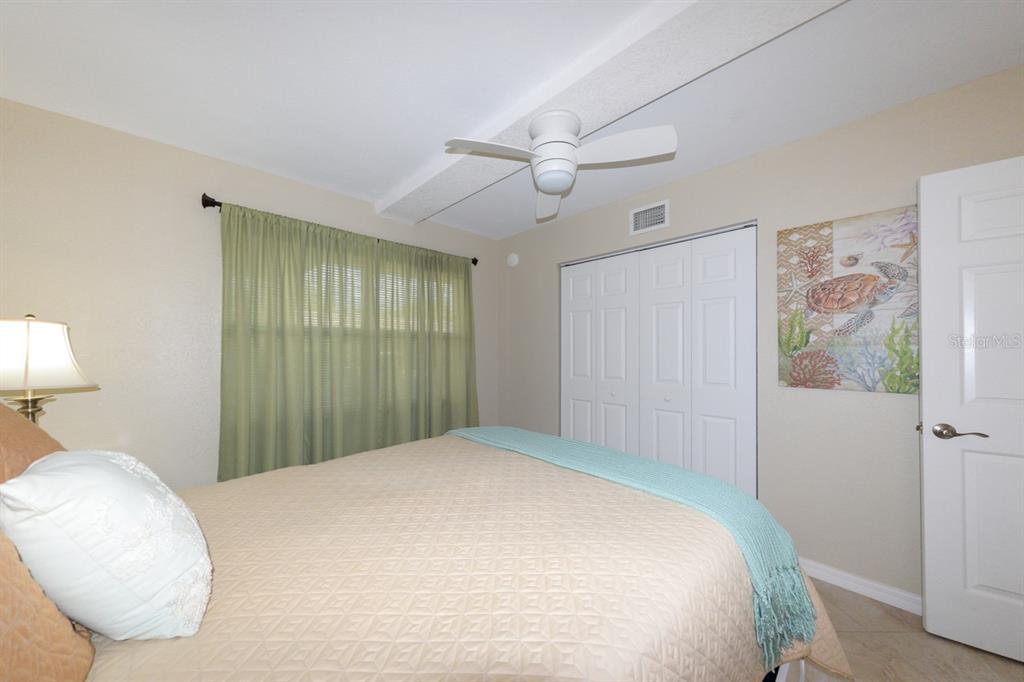 175 Kings Highway, Unit A7 Punta Gorda, FL 33983 - Photo 21 of 36 a bedroom with a large bed and a chandelier