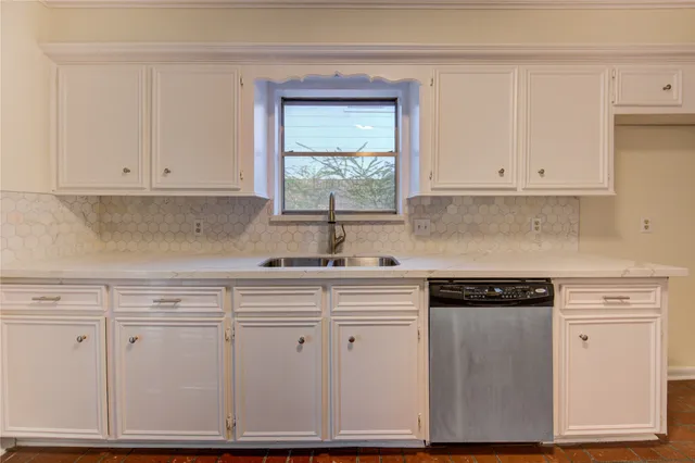 a kitchen with granite countertop white cabinets and a stove