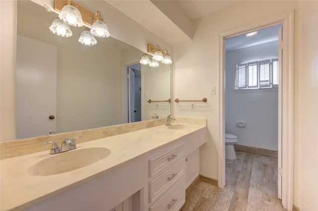 a bathroom with a granite countertop double vanity sink and a mirror
