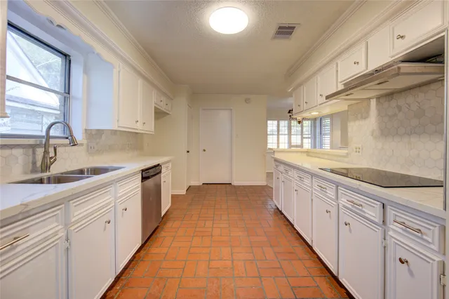 a large white kitchen with granite countertop a sink