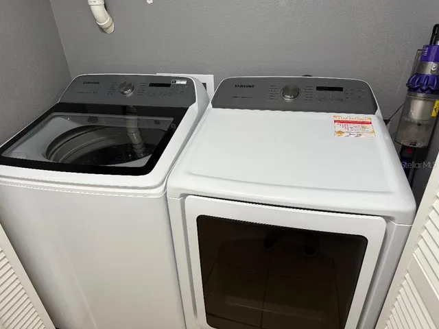 a view of a bench sitting on a table and chairs in a yard