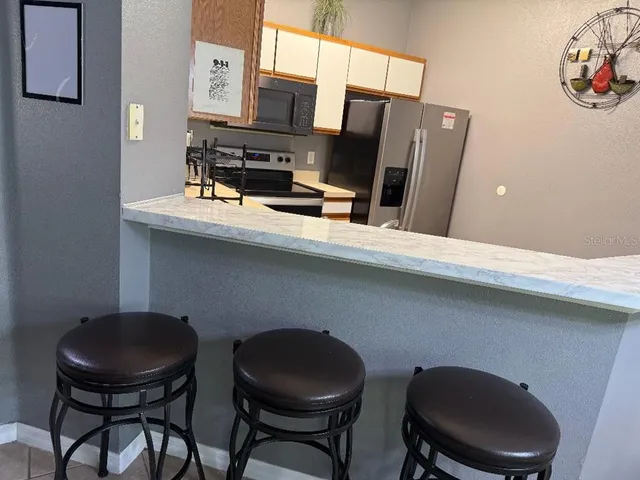 a kitchen with stainless steel appliances a dining table and chairs