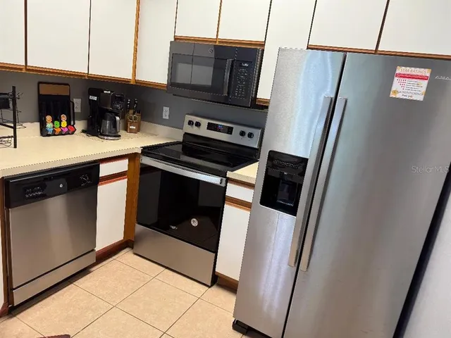 a kitchen with stainless steel appliances a refrigerator sink and microwave