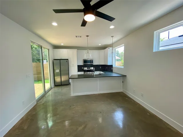 a view of kitchen with refrigerator and window
