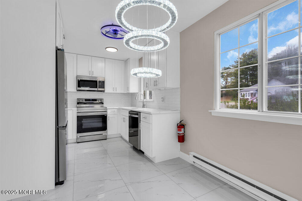 9B Juniper Lane, Unit 50 Whiting, NJ 08759 - Photo 14 of 28 a kitchen with stainless steel appliances a stove a sink and a refrigerator