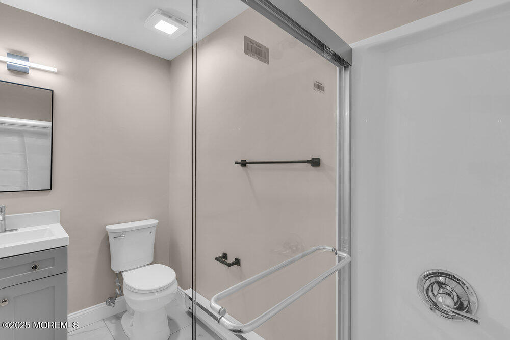 9B Juniper Lane, Unit 50 Whiting, NJ 08759 - Photo 22 of 28 a bathroom with a toilet sink vanity and shower