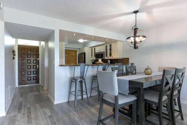 a view of a dining room with furniture a chandelier and wooden floor