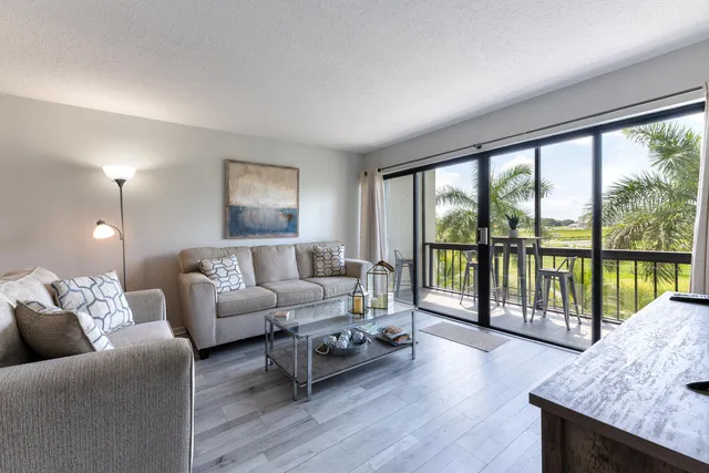 a bedroom with a bed a mirror on dresser and a wooden floor