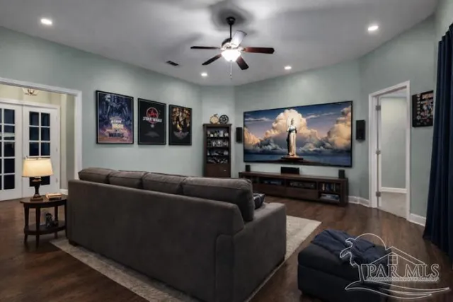 a view of a livingroom with a ceiling fan and wooden floor