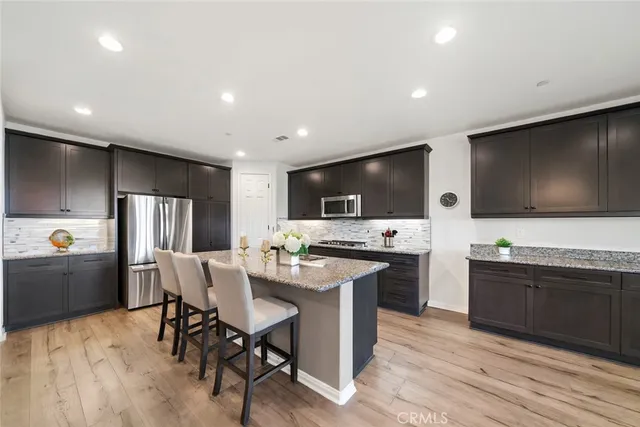 a kitchen with stainless steel appliances kitchen island granite countertop a sink and cabinets