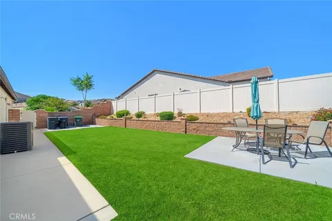 a view of a backyard with table and chairs potted plants and a palm tree