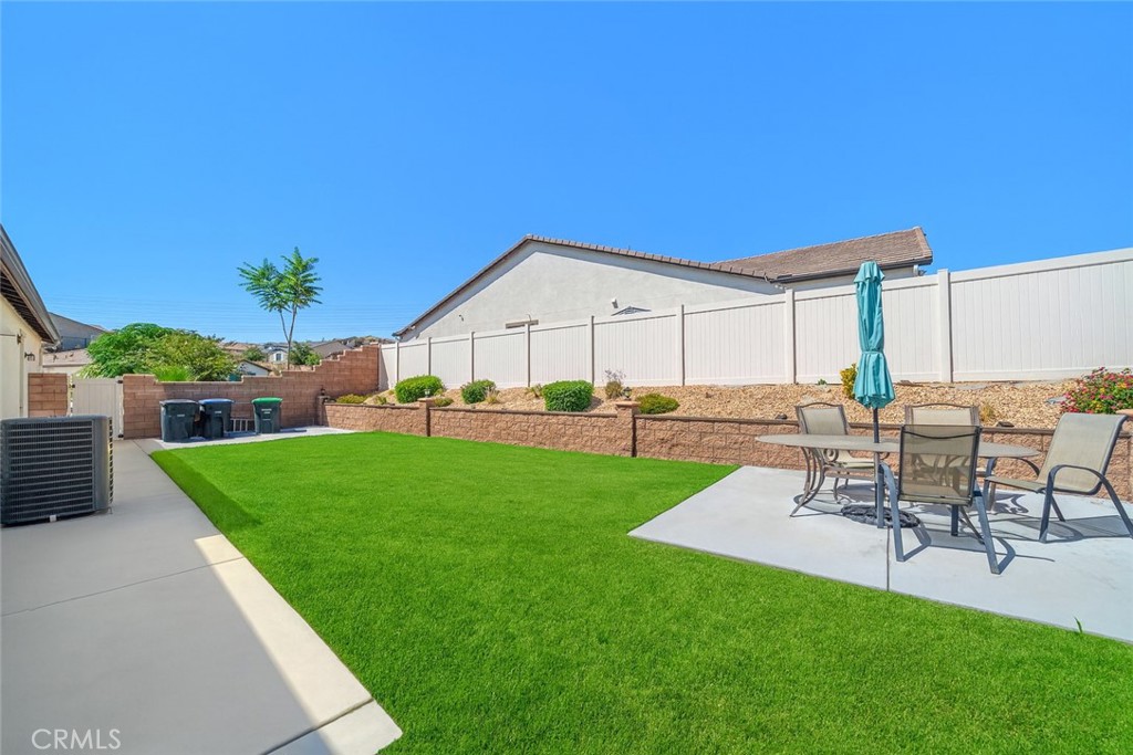 1537 Yucca Court Calimesa, CA 92320 - Photo 7 of 16 a view of a backyard with table and chairs potted plants and a palm tree
