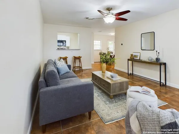 a living room with furniture and a ceiling fan