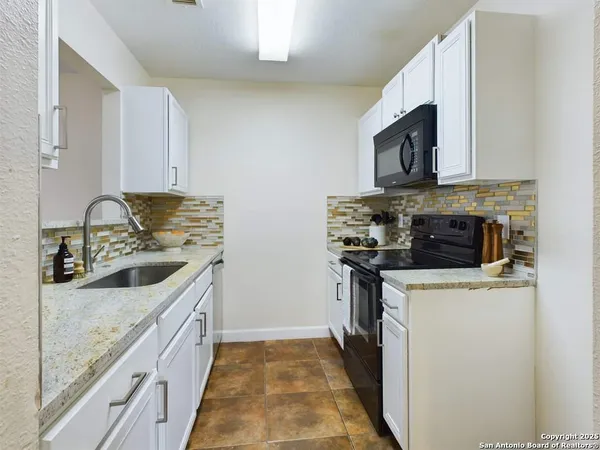 a kitchen with stainless steel appliances granite countertop a stove a sink and a microwave