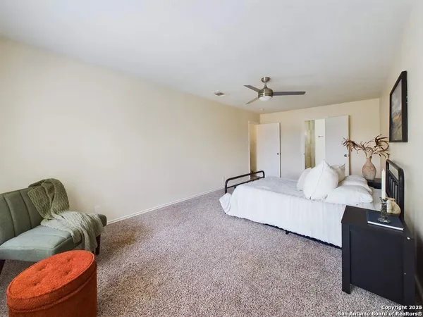a living room with furniture a ceiling fan and a rug